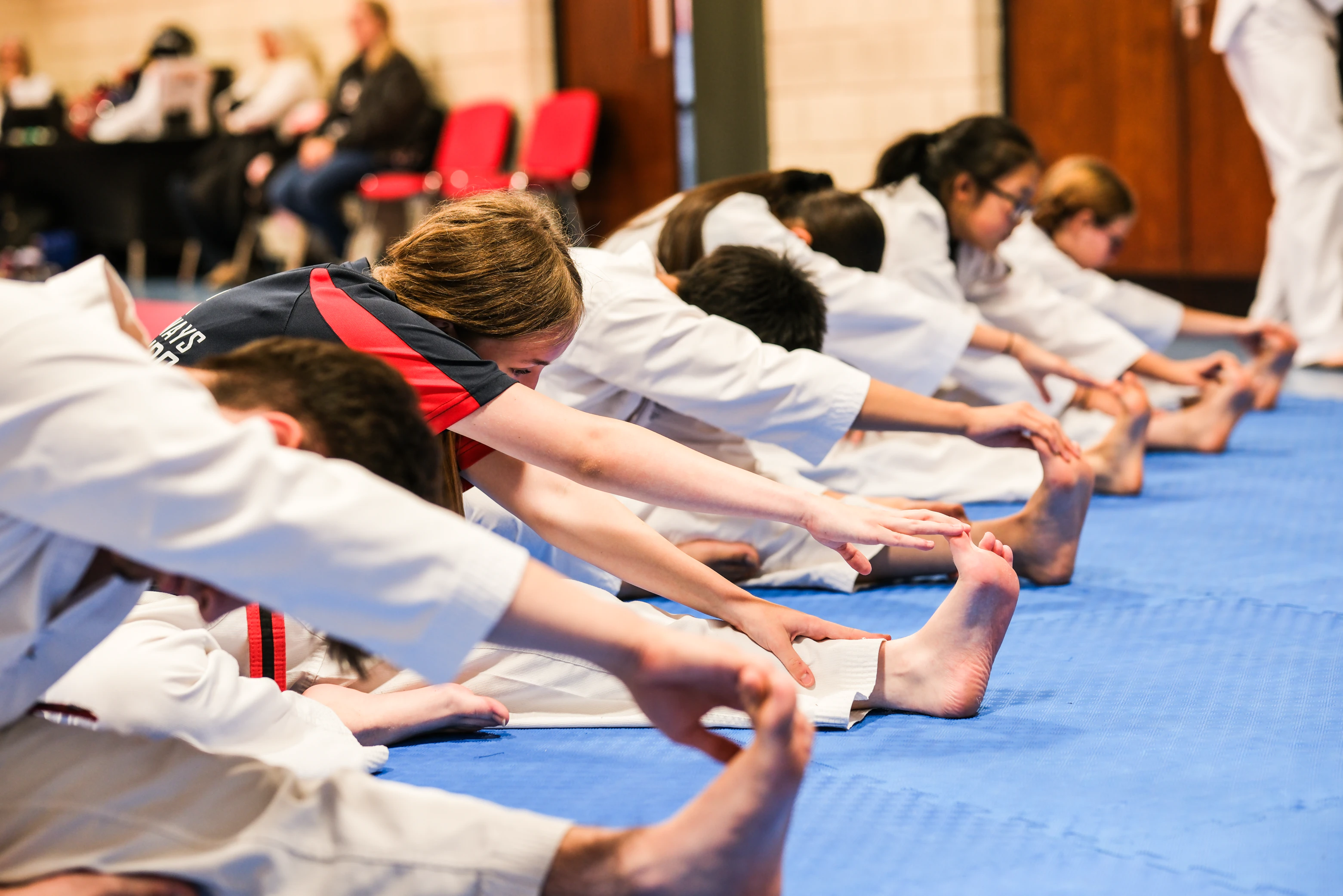 Creative Ways Taekwondo students stretching together on the mats